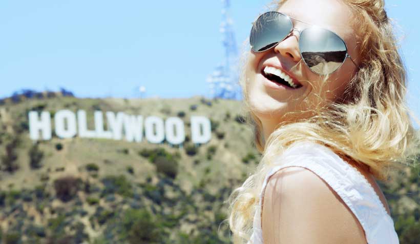 Woman posing near Hollywood signn